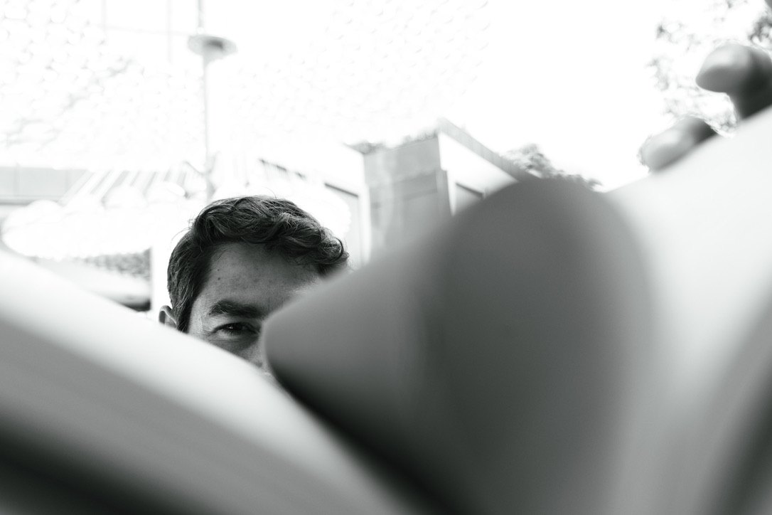 Manuel Betancourt&rsquo;s eye peeking over the pages of an open book